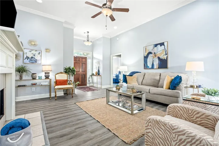 Enter into a welcoming living space boasting high ceilings, crown molding, and durable plank flooring.