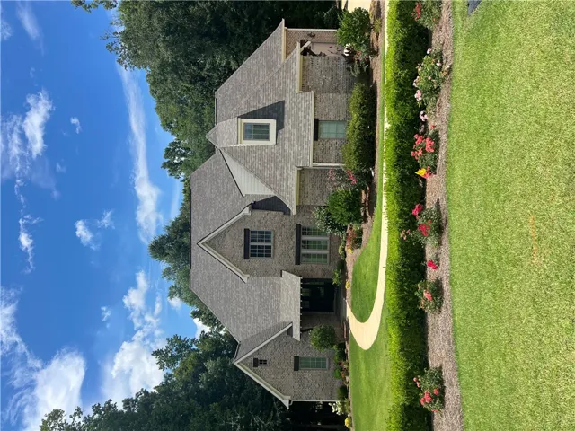 A well-maintained lawn and established landscaping enhance this attractive brick and shingle residence.