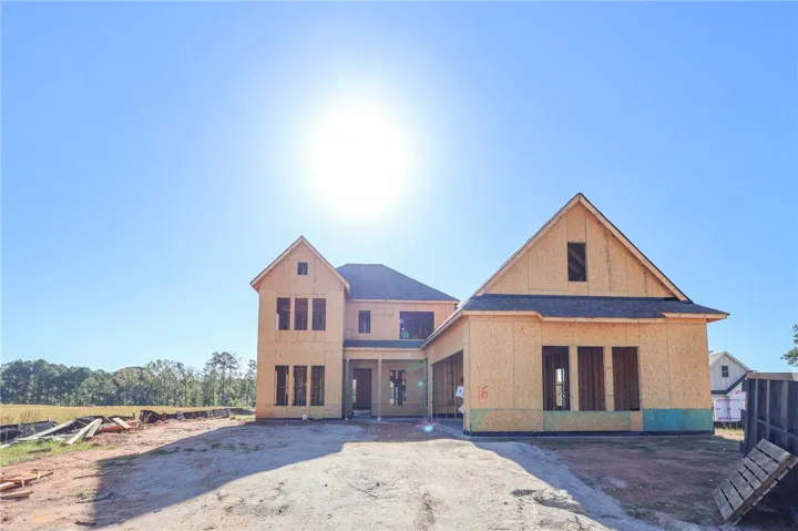 A newly framed multi-level home takes shape under a clear sky.