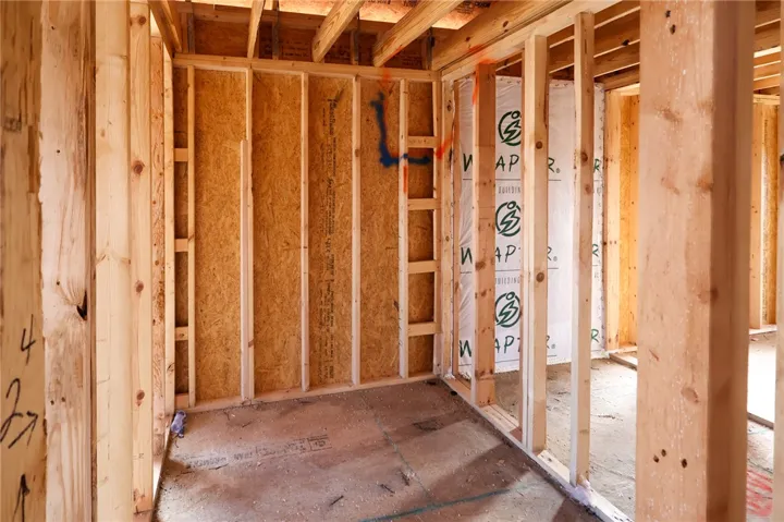 Exposed wood studs and subflooring showcase the sturdy quality of this new construction framing.