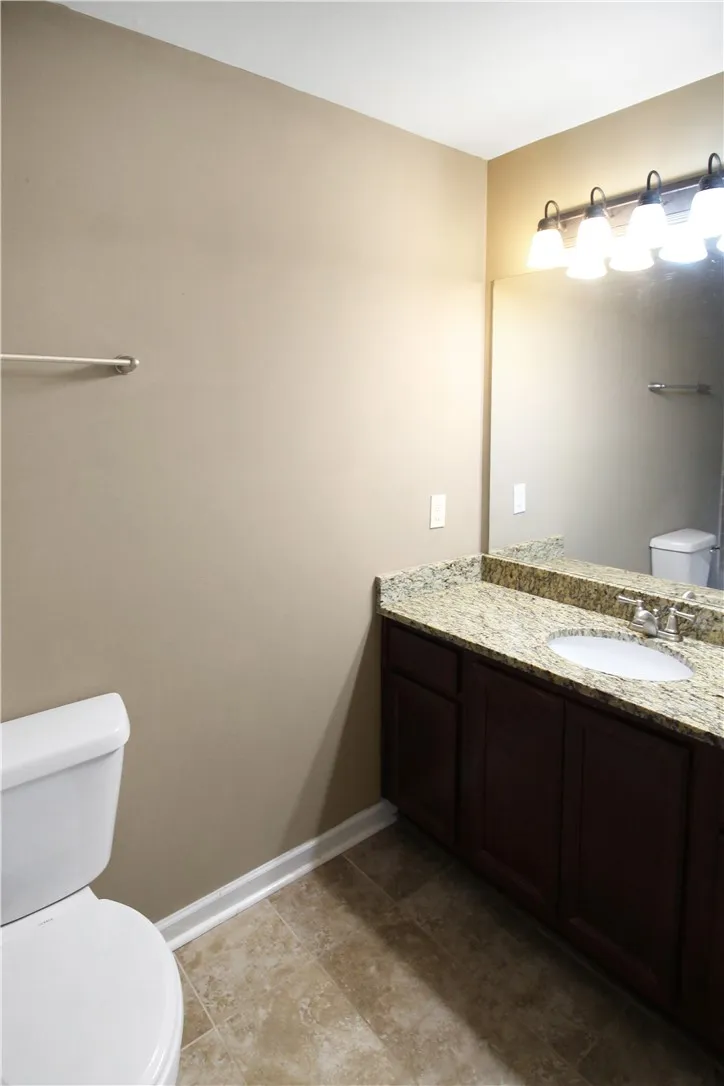Granite counters and tile flooring highlight this well-appointed bathroom.