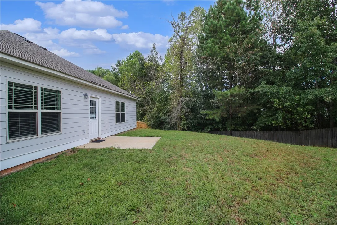 A verdant lawn provides a private outdoor retreat adjacent to the home's siding and patio.