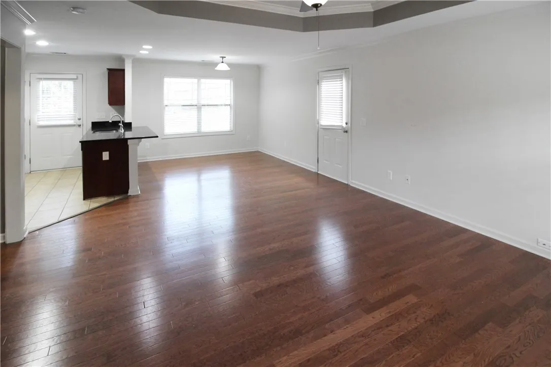 Refined wood floors and bright windows create an inviting, airy common area with a convenient kitchen island.