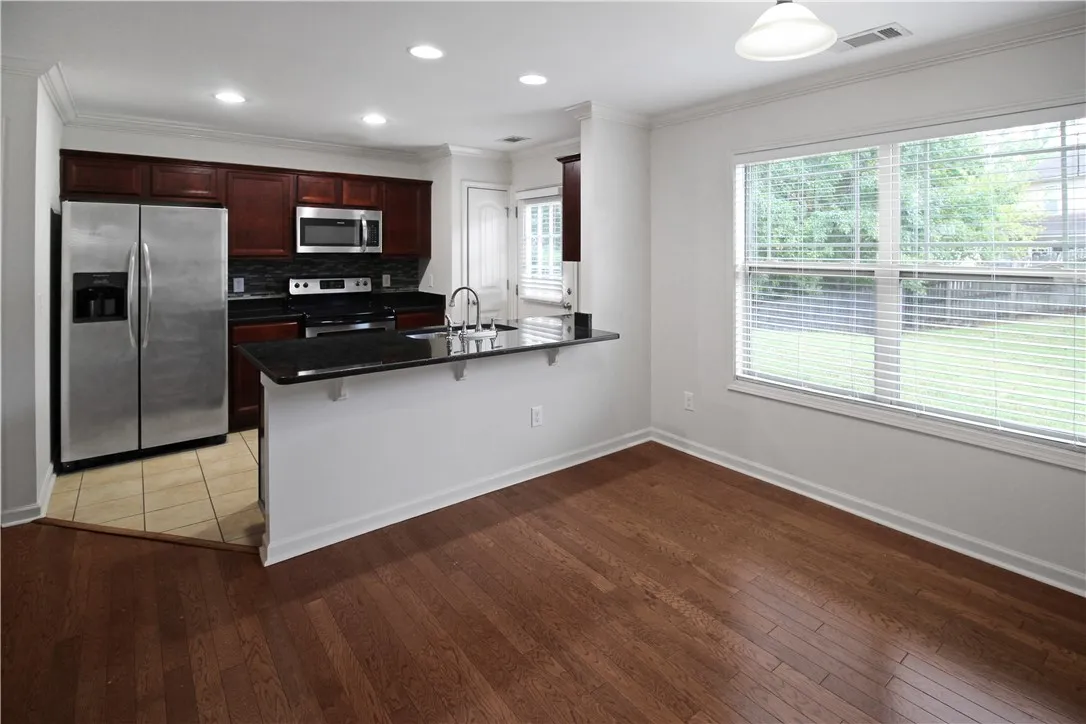 A well-appointed kitchen and dining area feature rich cabinetry and generous natural light.