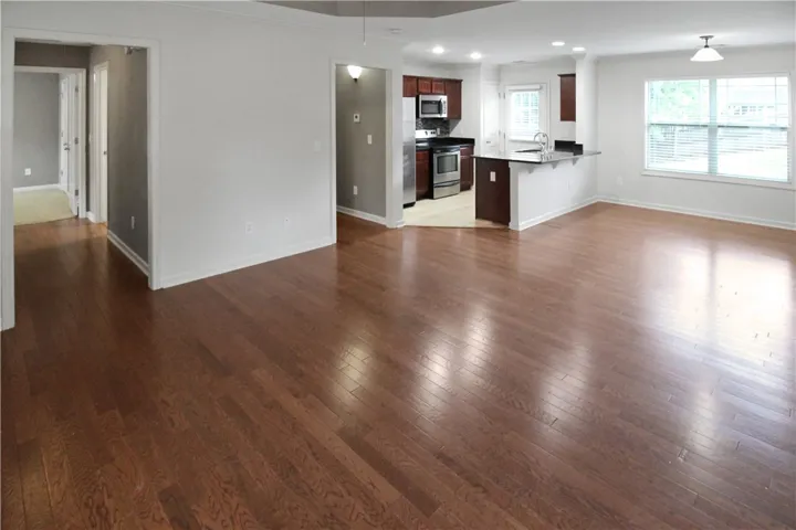 Rich hardwood floors gleam in this inviting open-concept living space with a connected kitchen.