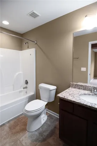 Functional full bathroom with durable tiled floors and a sleek vanity offers everyday convenience.