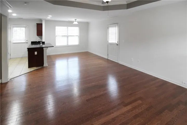 Refined wood floors and bright windows create an inviting, airy common area with a convenient kitchen island.