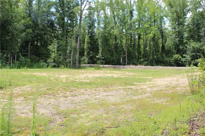 A spacious lot offering ample open space, bordered by mature trees for privacy and a tranquil setting.