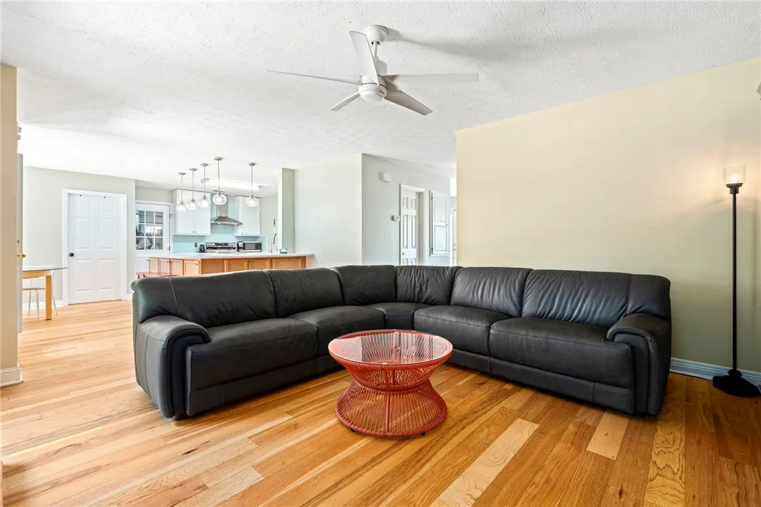 Hardwood floors flow through this inviting living area, which connects seamlessly to a modern kitchen.