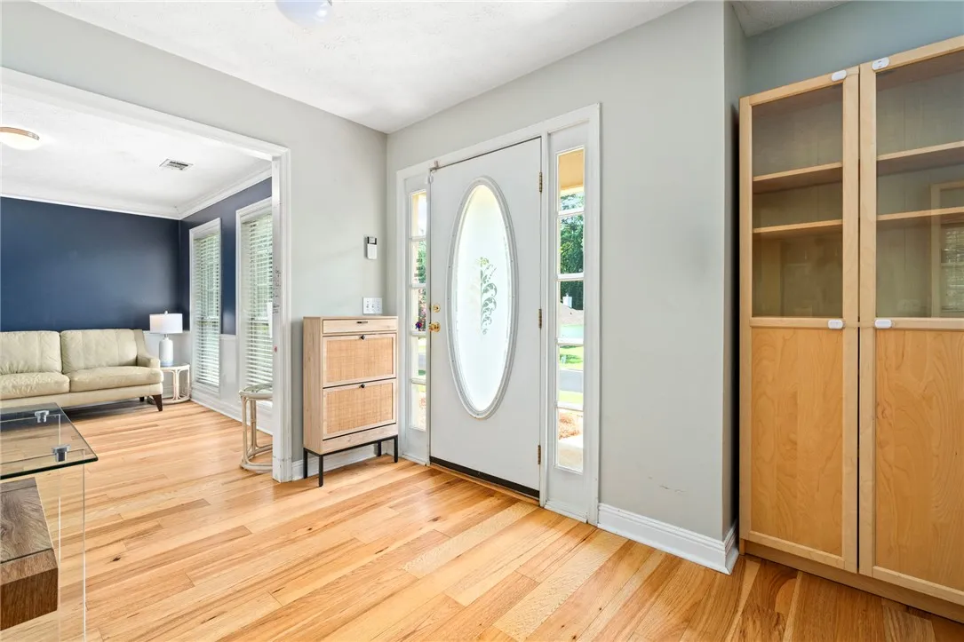 A welcoming entryway with natural hardwood flooring and abundant light from the front door's sidelights.