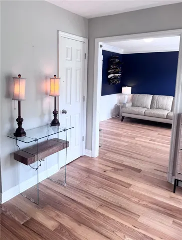 Warm hardwood flooring flows throughout this inviting entryway and adjacent living space.