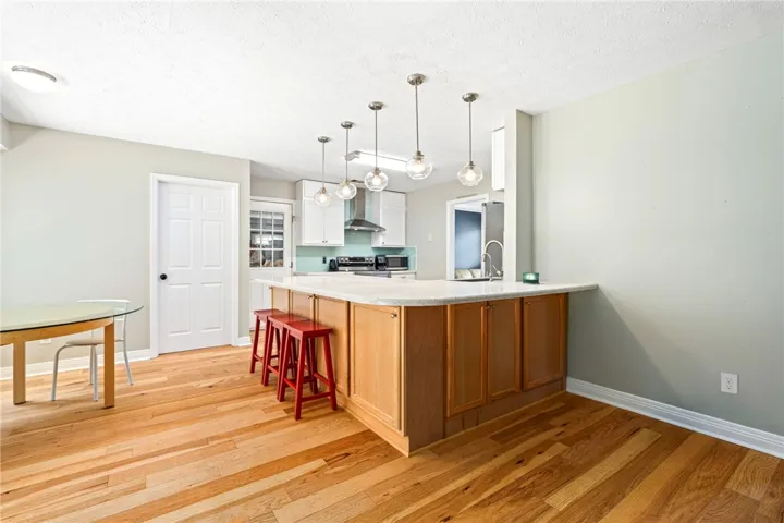 Hardwood floors stretch across this kitchen, offering a peninsula with casual seating and ample counter space.