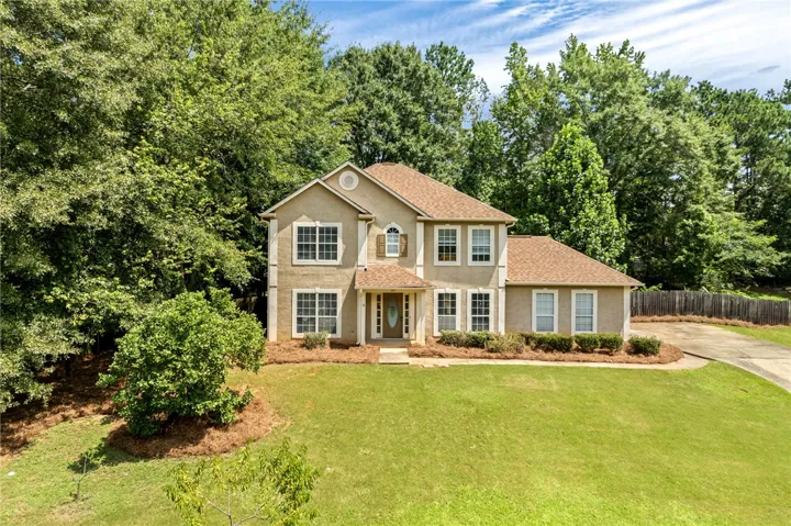 A classic facade with a welcoming covered entry complements the lush, verdant landscaping.