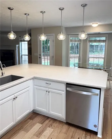 A well-appointed kitchen island with pendant lighting provides a functional and bright prep area.