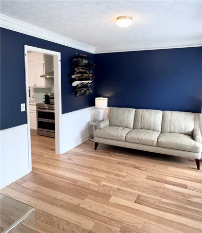 Bright hardwood floors flow through this welcoming living space with clean crown molding.