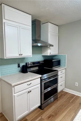 A well-appointed kitchen features a modern stainless steel range and a stylish blue tile backsplash.