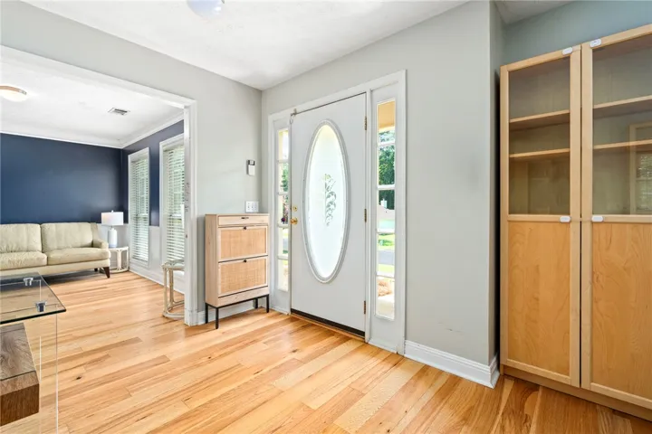 A welcoming entryway with natural hardwood flooring and abundant light from the front door's sidelights.