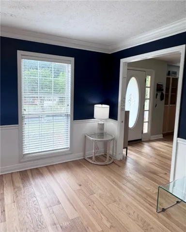 Bright hardwoods define this inviting entry space, complemented by crisp wainscoting and crown molding.