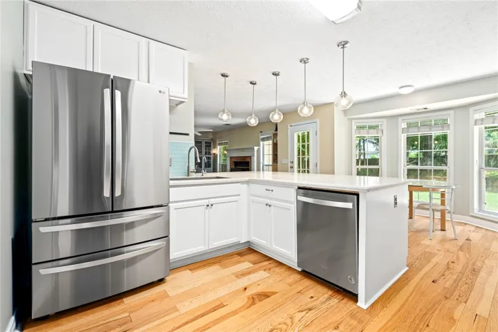 A well-appointed kitchen features stainless steel appliances, gleaming hardwood flooring, and ample natural light.
