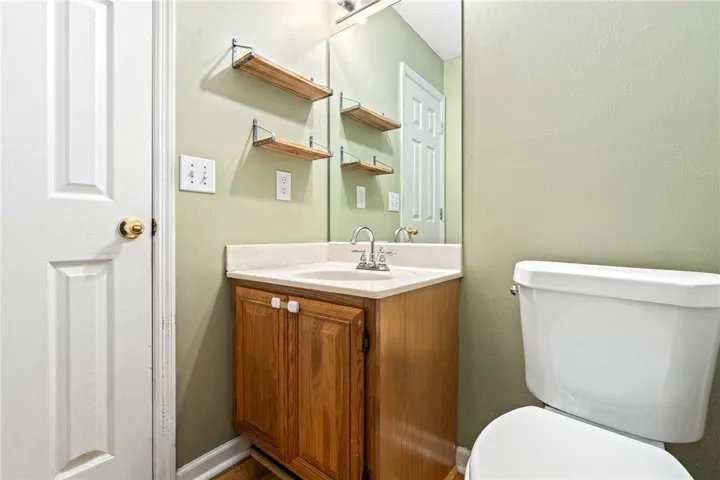 A well-appointed half bath features a vanity with a white countertop and a convenient toilet.