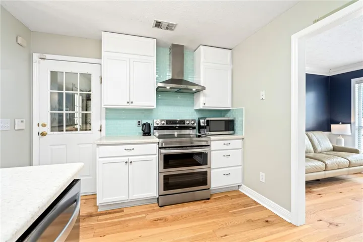 Modern kitchen with white cabinetry, stainless steel appliances, and a refreshing tile backsplash.