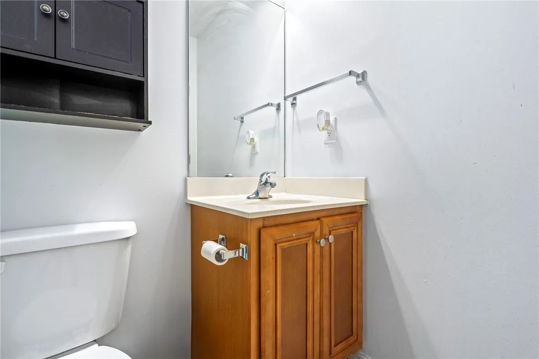 A compact bathroom vanity with a coordinating wall cabinet and toilet.
