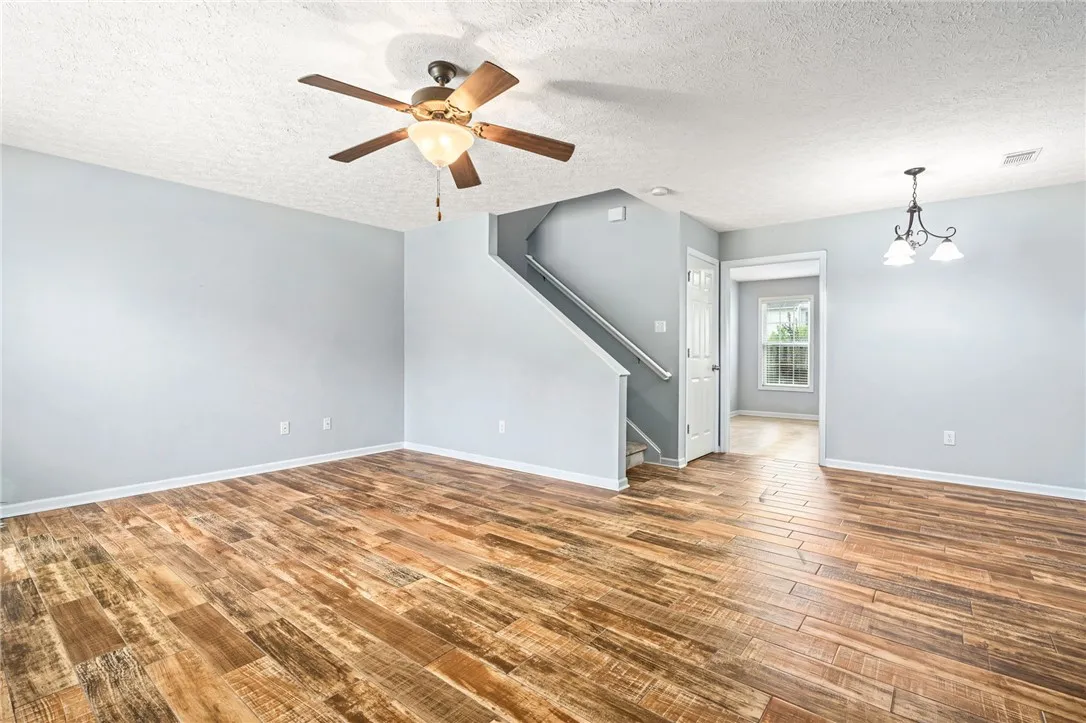Rich wood flooring complements the staircase, creating a warm and inviting living space.