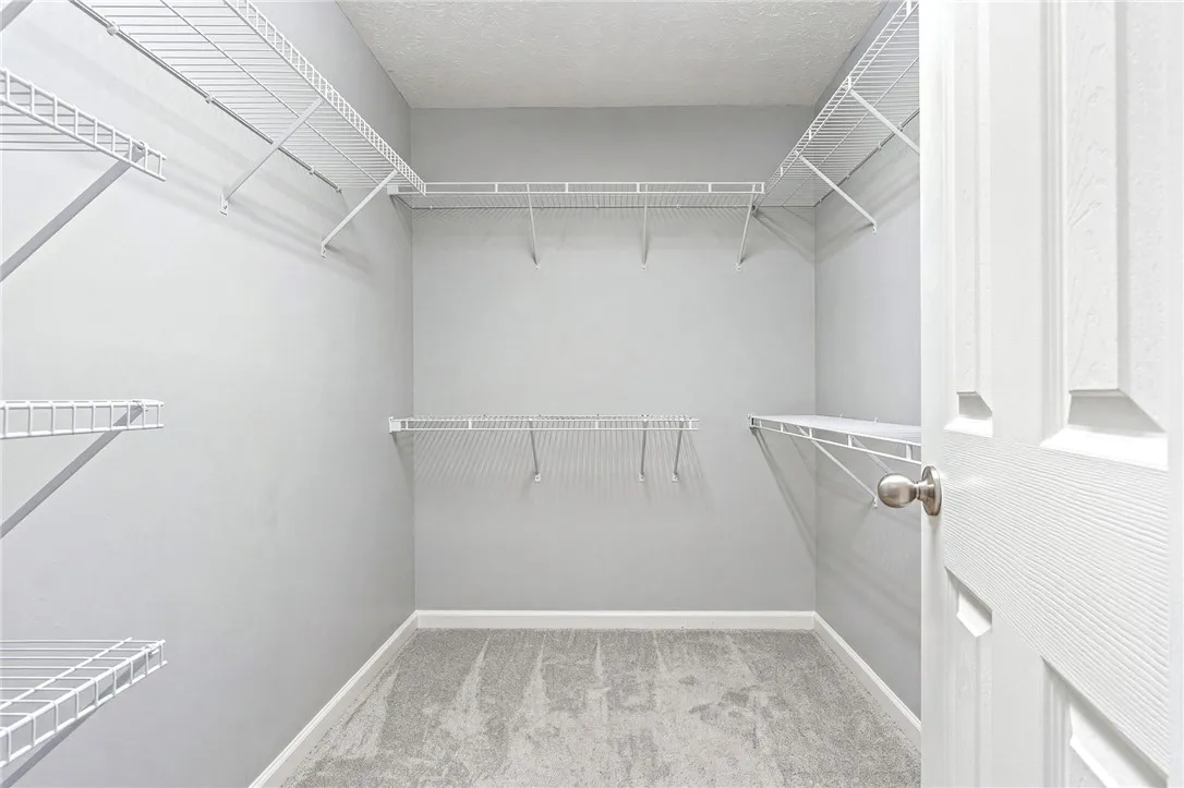 Well-appointed with wire shelving, this walk-in closet offers ample storage for an organized wardrobe.