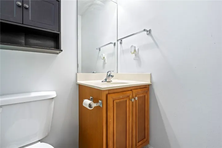 A compact bathroom vanity with a coordinating wall cabinet and toilet.