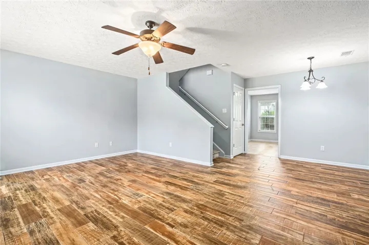 Rich wood flooring complements the staircase, creating a warm and inviting living space.