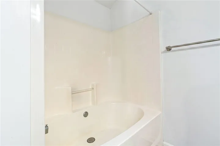 A well-maintained tub with integrated tile surround offers a clean, functional bathing space.