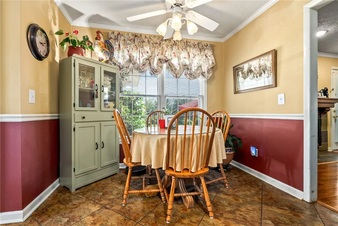 A cozy breakfast nook features a four-chair dining set and a charming ceiling fan.