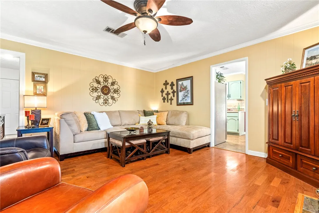 Laminate hardwood floors flow through this welcoming living area, connecting seamlessly to an adjacent kitchen.