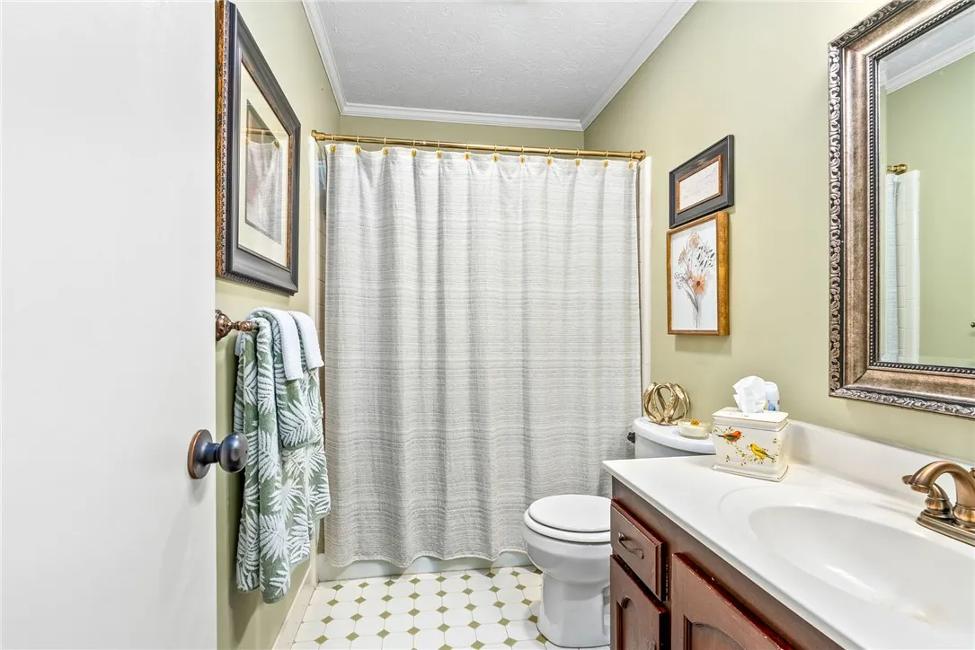 Well-lit bathroom with a vanity and a shower-tub combination.