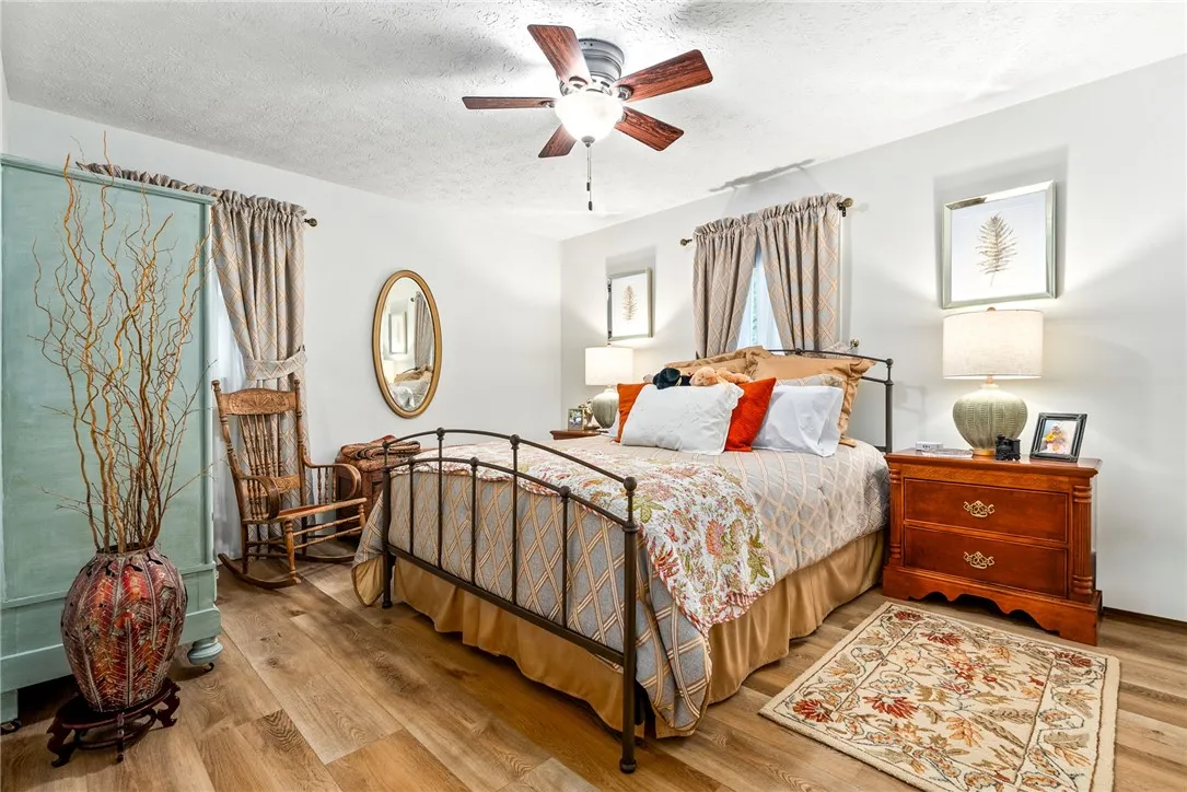 Cozy bedroom with warm LVP flooring and a modern ceiling fan for ultimate comfort.