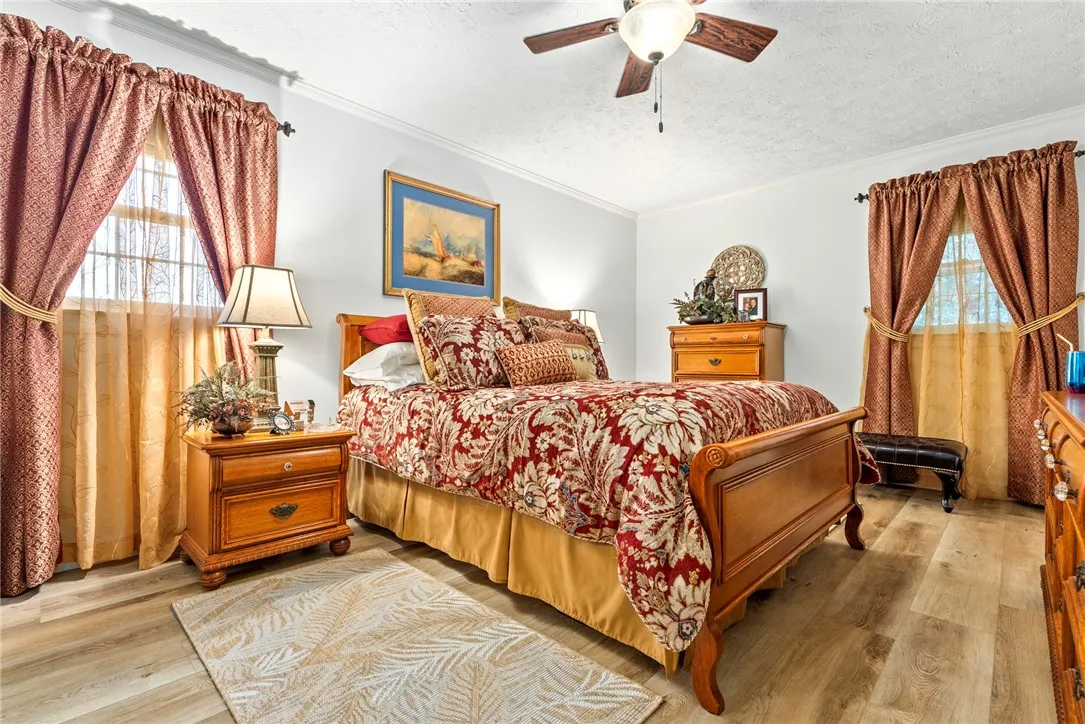 Discover comfort in this serene primary bedroom, complete with durable flooring and a ceiling fan.
