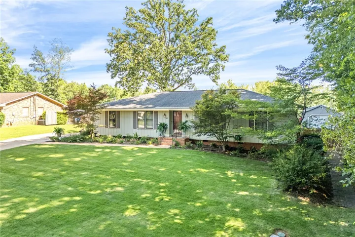 A well-maintained lawn welcomes you to this classic residence with mature trees and thoughtful landscaping.