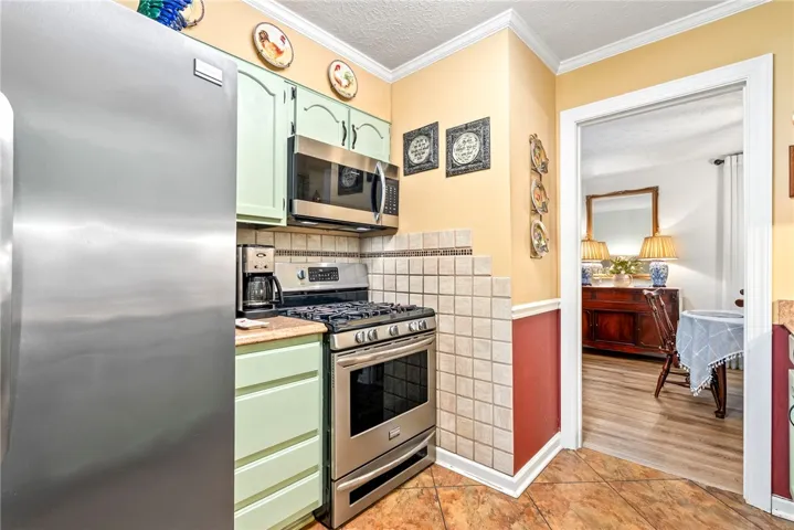 A compact kitchen boasts stainless steel appliances, vibrant cabinetry.