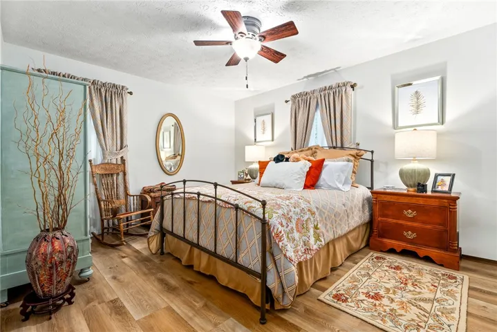 Cozy bedroom with warm LVP flooring and a modern ceiling fan for ultimate comfort.