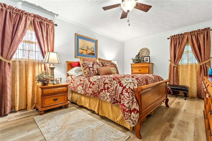 Discover comfort in this serene primary bedroom, complete with durable flooring and a ceiling fan.