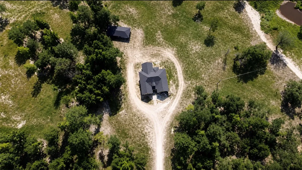 An aerial perspective reveals a secluded estate nestled within a verdant, sprawling landscape.