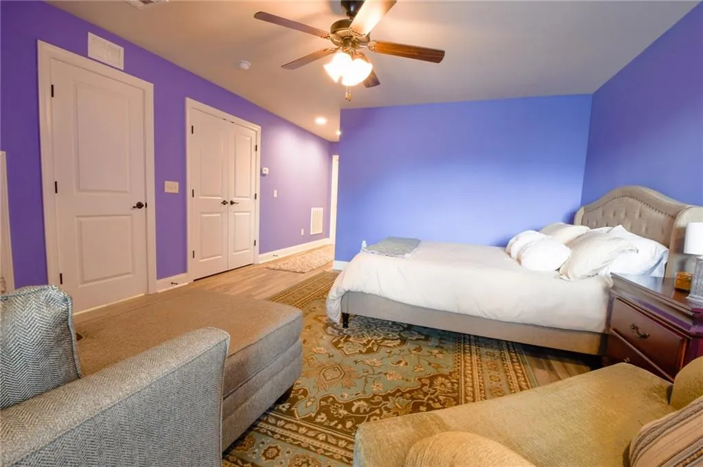 A comfortable bedroom featuring soft flooring and abundant natural light.