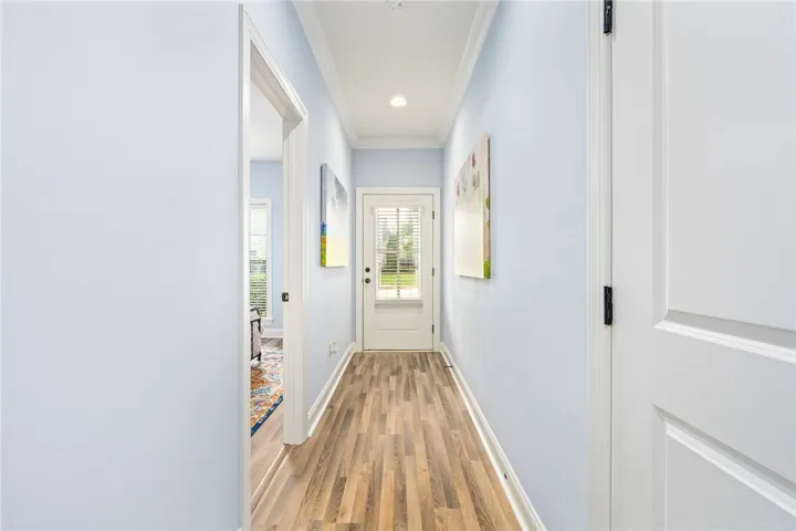 A welcoming entryway with recessed lighting and crown molding leads into a bright, inviting open floor plan.