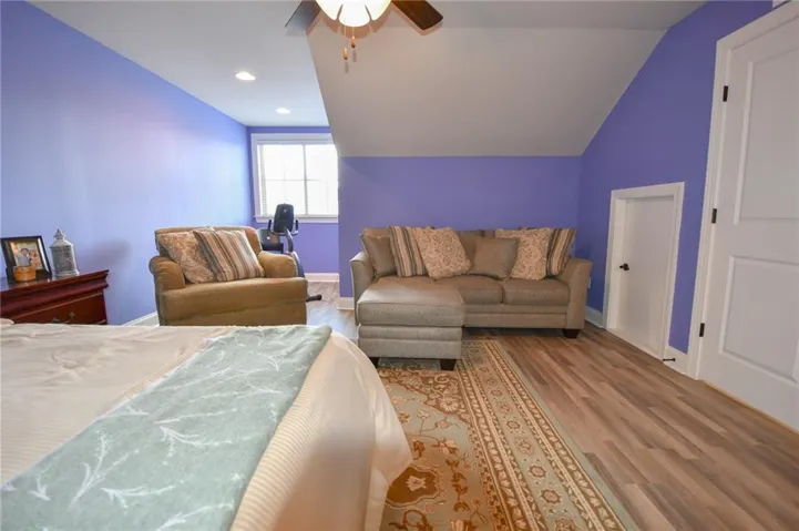 A versatile room featuring a vaulted ceiling and rich hardwood flooring, ready for your personalized touch.