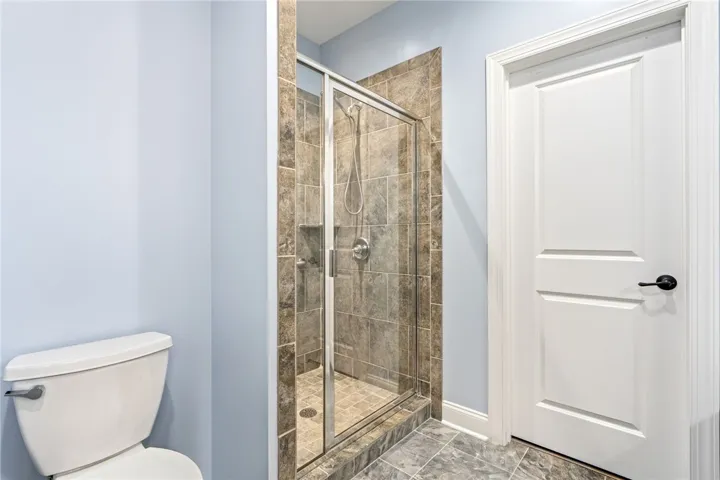 A well-appointed bathroom offers a convenient walk-in shower with tile surround