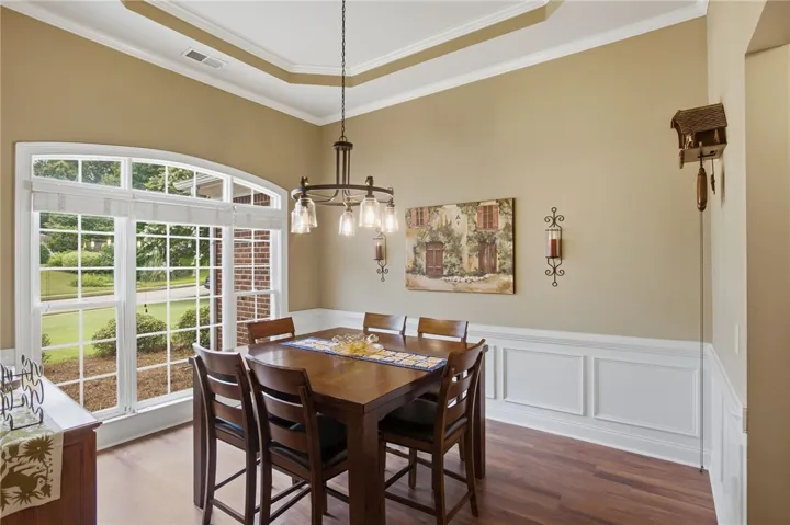 Features tray ceilings, rich wood flooring, and wainscoting.