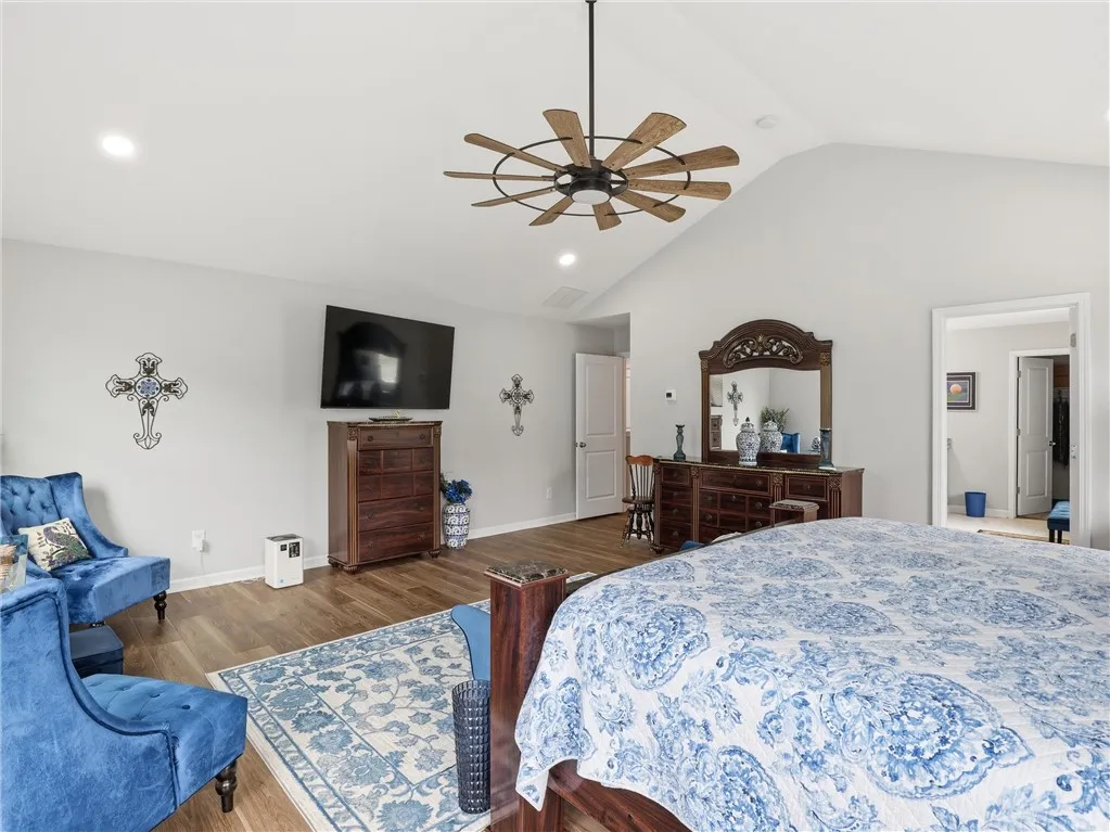 Vaulted ceilings and hardwood flooring elevate this primary bedroom.