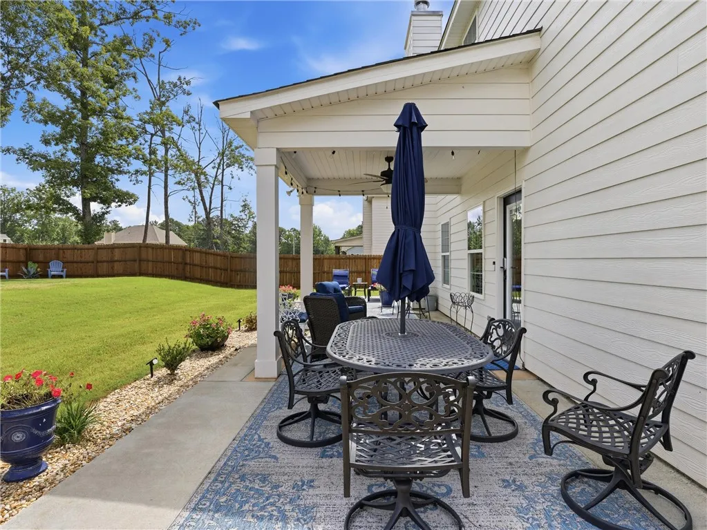 An inviting covered patio opens to a manicured lawn, perfect for outdoor leisure.