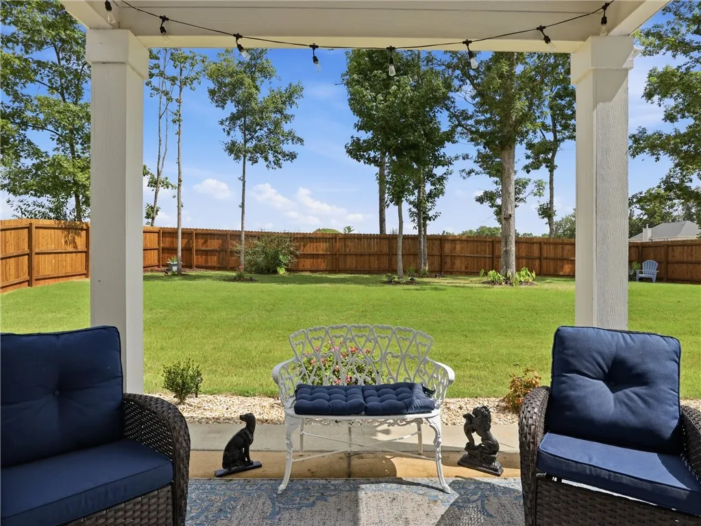 A spacious backyard with mature trees provides a peaceful outdoor retreat.