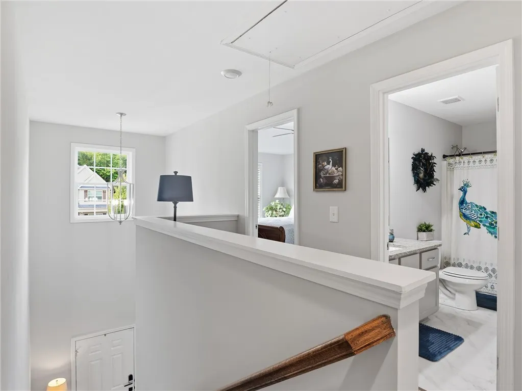 An inviting upstairs landing features an attic access point, leading to well-appointed rooms and a luminous bathroom.
